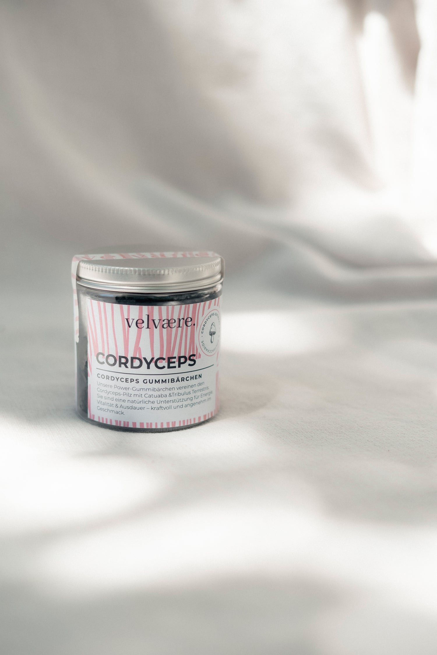 Velvaere Cordyceps Gummibärchen im Glas mit rosa Etikett auf hellem Hintergrund.